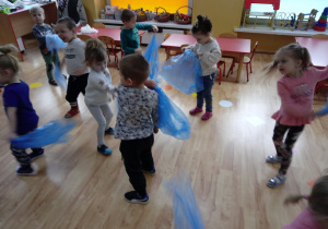 Dzieci tańczą z błękitną folią